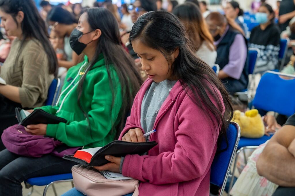 A group of young adults engaged in a worship gathering in Mexico City.