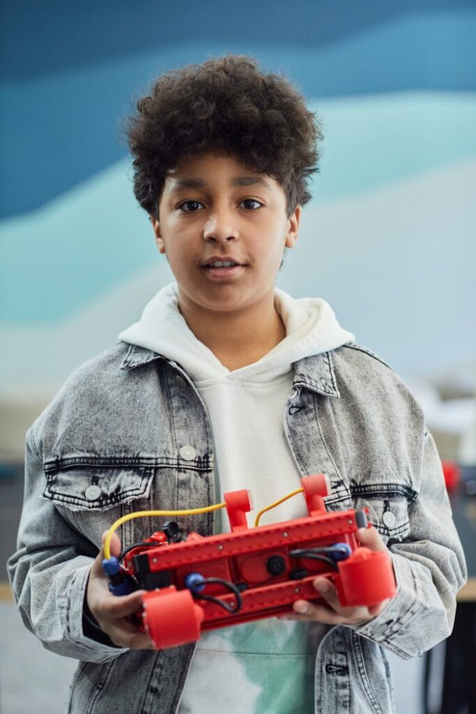 Boy holding a battery-operated toy project, showcasing creativity and innovation.